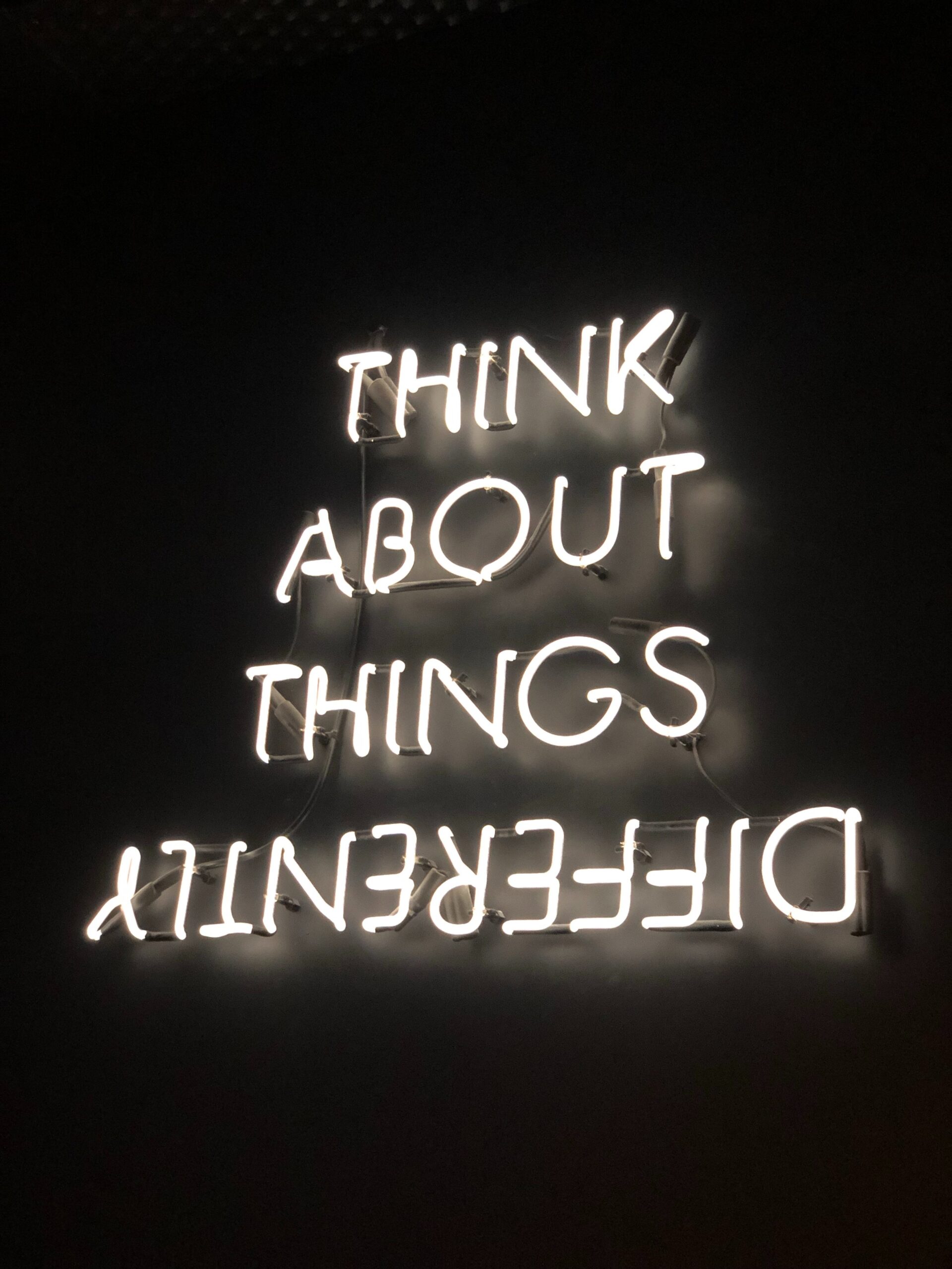 An illuminated sign that says "think about things differently"